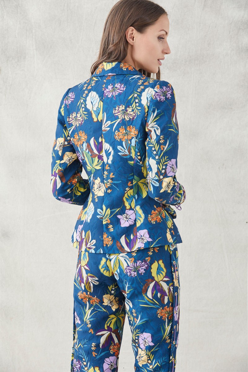 traje  para invitadas de bodas eventos fiestas nochevieja de apparentia  pantalon pitillo y chaqueta con ollados en los laterales y cordones de antelina malva en tejido jacquard con fondo azul oscuro y un precioso estampado de flores